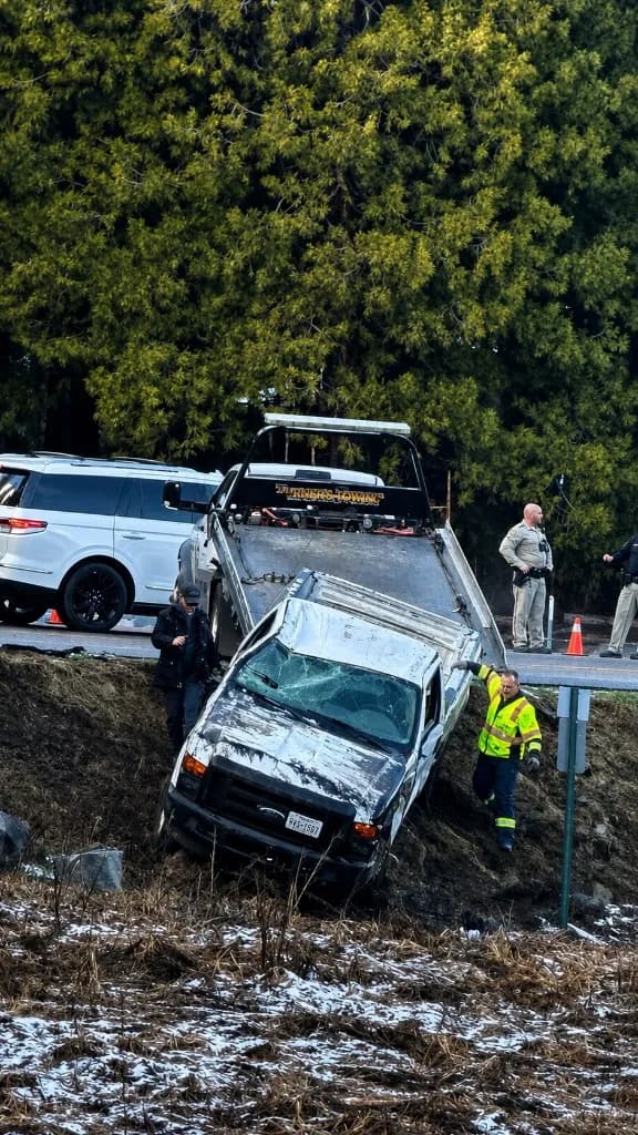 Turner's Towing operator recovering a vehicle from a steep embankment with law enforcement on scene